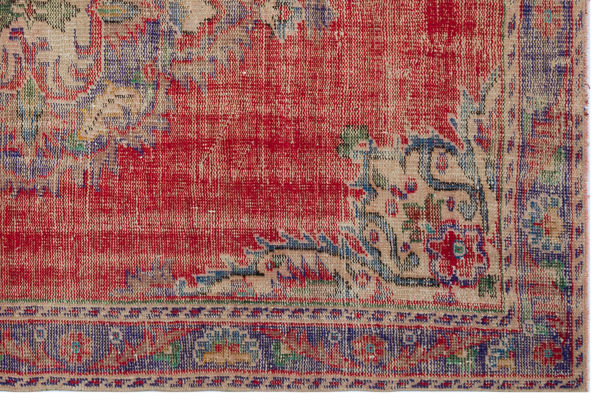 Distressed red, beige, and blue traditional rug with a floral medallion pattern and a detailed border.