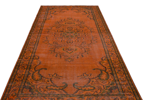 Load image 1 in gallery view. Burnt orange vintage rug with a central floral medallion and dark green border patterns on a white background.
