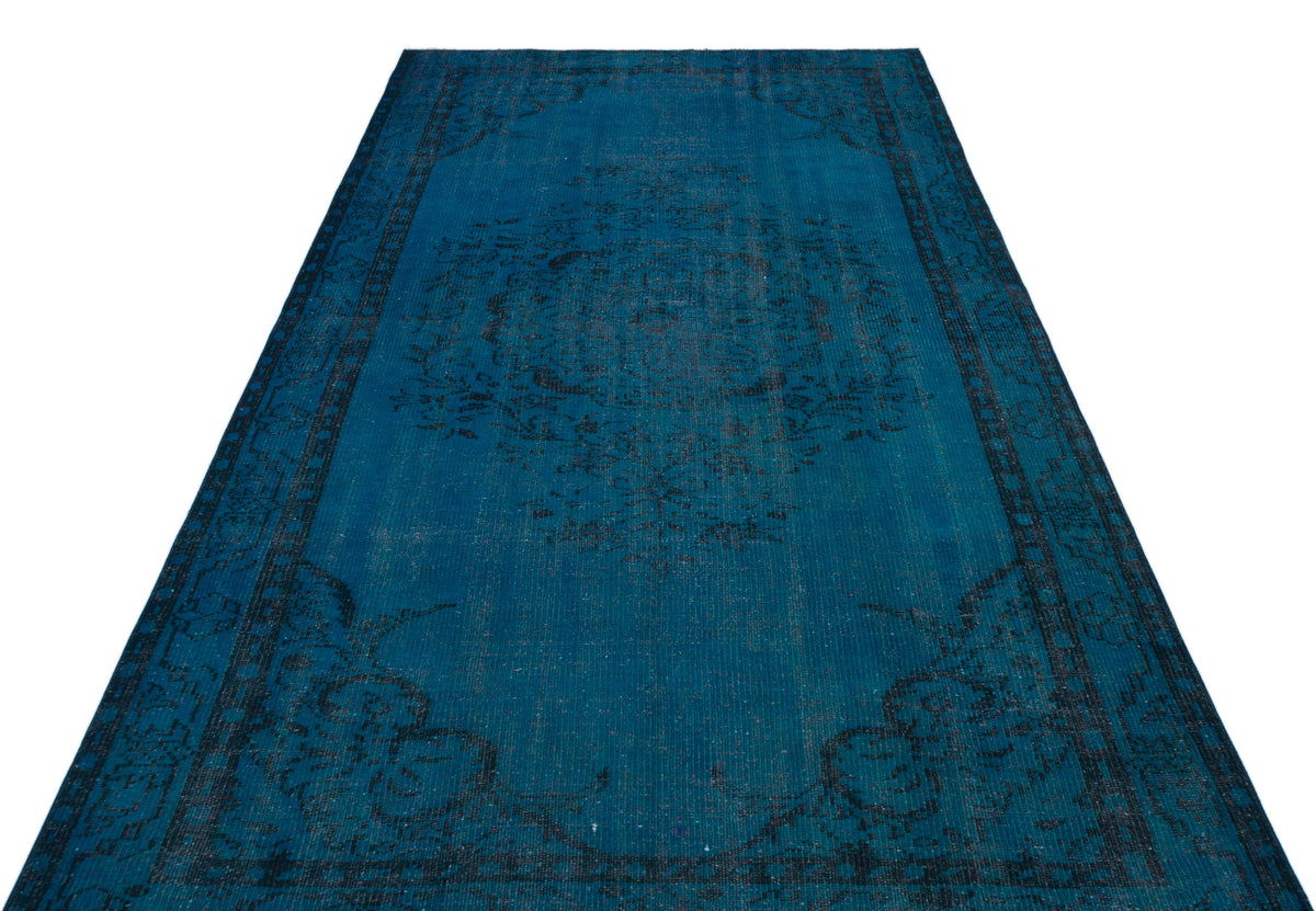 Deep teal distressed rug with a dark charcoal floral medallion and border pattern on a white background.