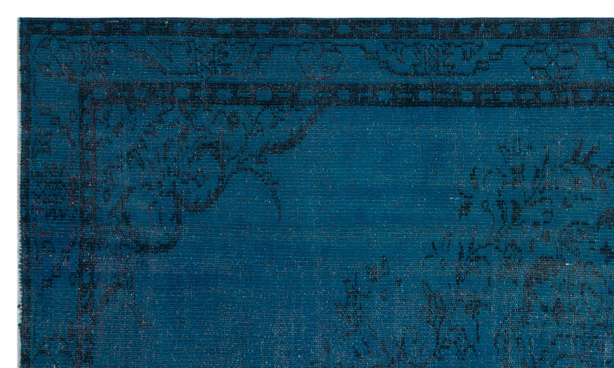 Teal and black traditional rug with a distressed floral medallion pattern and a geometric border.