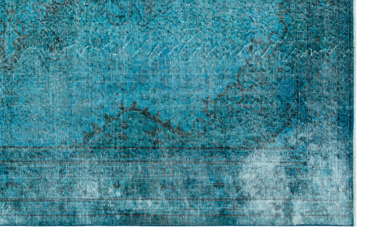 Teal and black distressed rug with a traditional ornate medallion pattern and a faded, weathered texture.