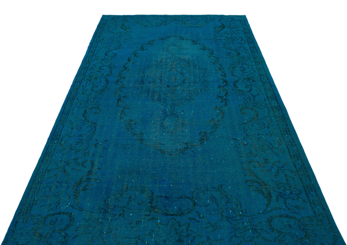 Monochromatic teal rug with a distressed traditional medallion and floral border pattern on a white background.