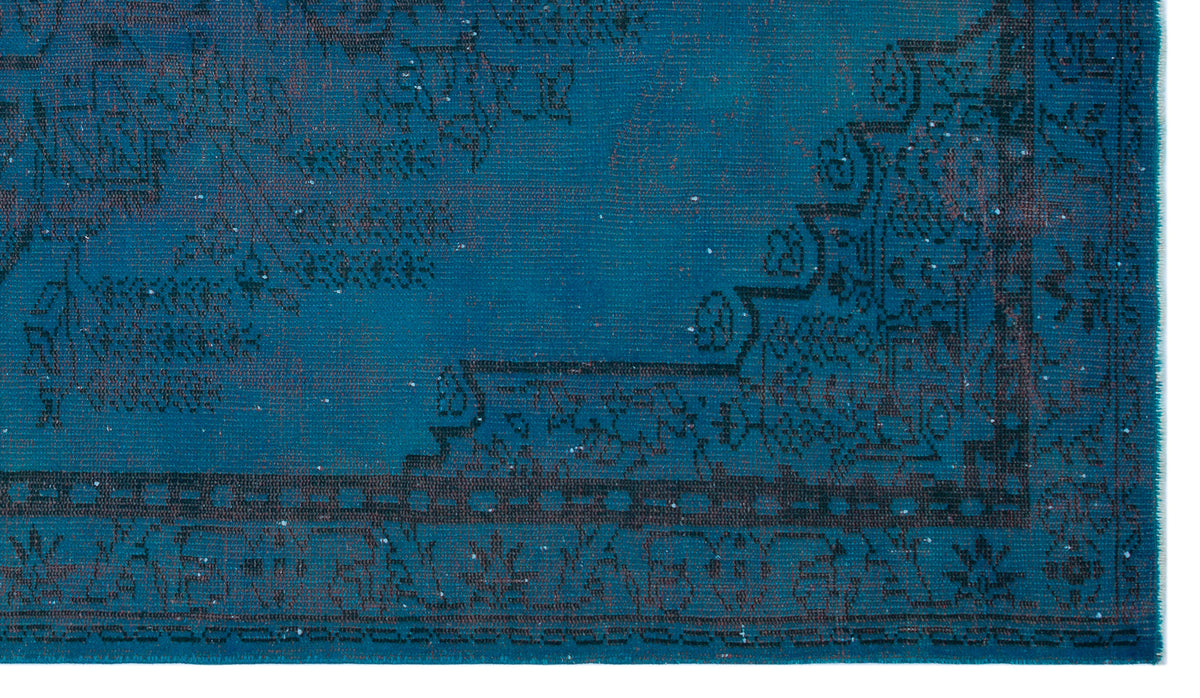 Teal rug with a distressed black traditional floral medallion pattern and a geometric border.
