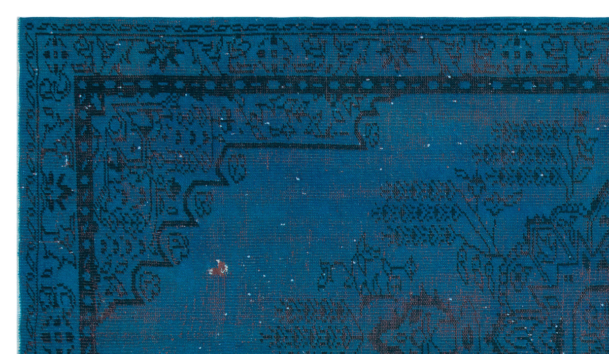 Deep blue rug with a black traditional floral border and distressed, faded pattern on a white background.