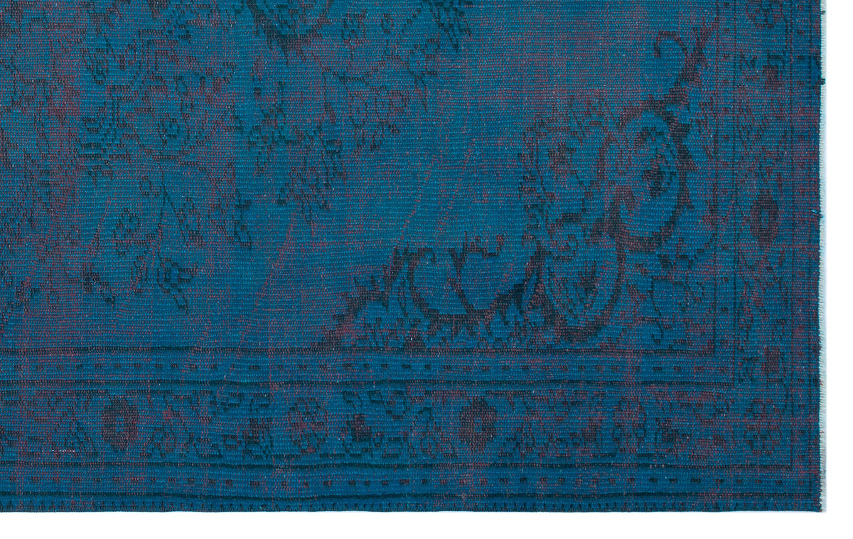 Teal and dark purple rug with a traditional distressed floral medallion pattern and a bordered edge.
