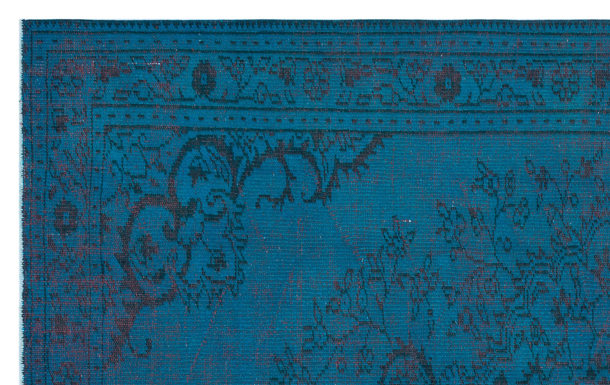 Teal and black traditional rug with a distressed floral medallion pattern and a detailed border.