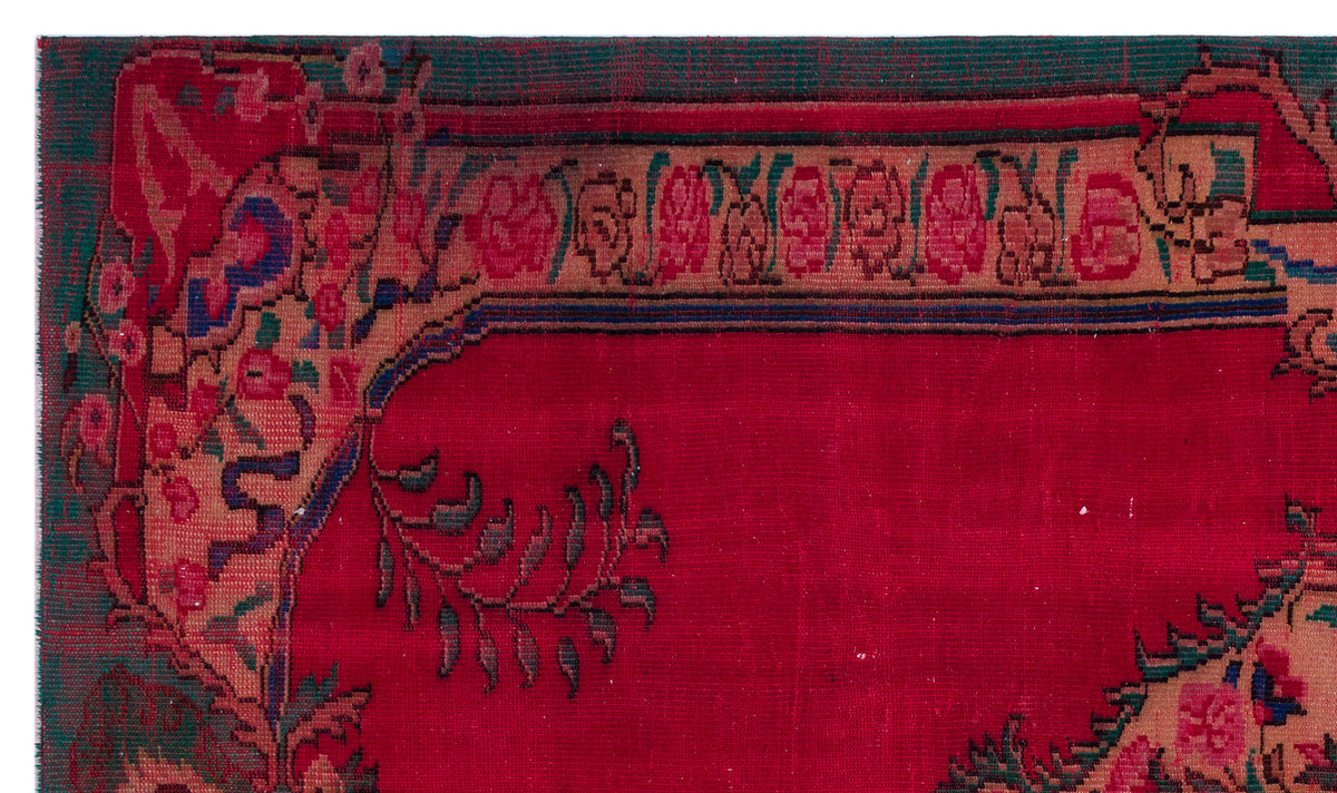 Red traditional rug with a floral border in pink, green, and tan on a white background.