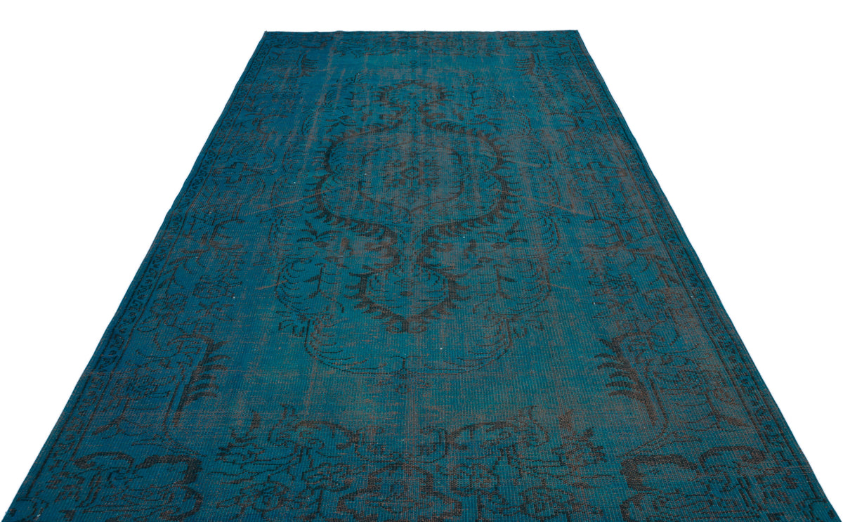 Teal and charcoal distressed rug with a traditional central medallion pattern on a white background.