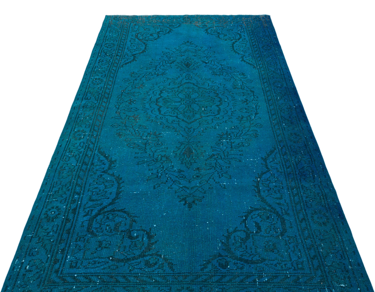 Teal distressed area rug with a dark blue traditional floral medallion pattern and ornate border.