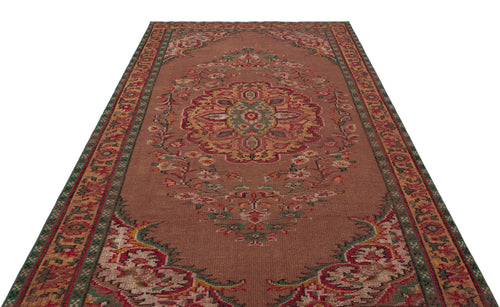 Load image 1 in gallery view. Brown traditional rug with a central floral medallion and ornate green and red border patterns.