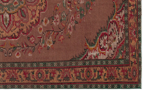 Load image 1 in gallery view. Brown traditional rug with a floral medallion pattern, intricate red and green border, and woven texture.