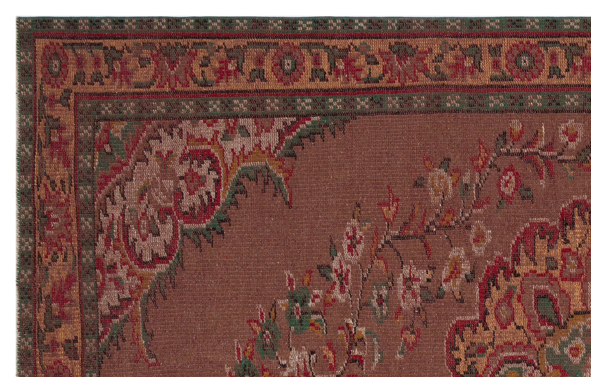 Brown traditional rug with a red and green floral border and ornate central medallion pattern.