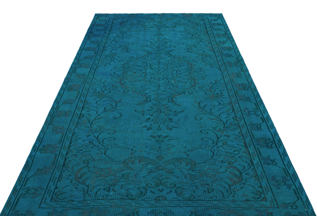 Teal runner rug with a dark, distressed traditional floral medallion pattern and a bordered edge.