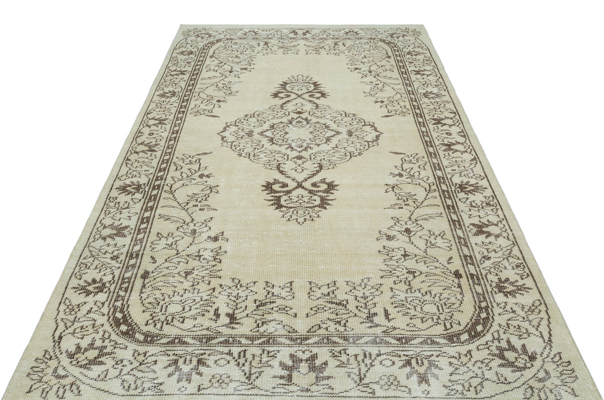 Beige and brown vintage-style rug with a central floral medallion and ornate border pattern on a white background.