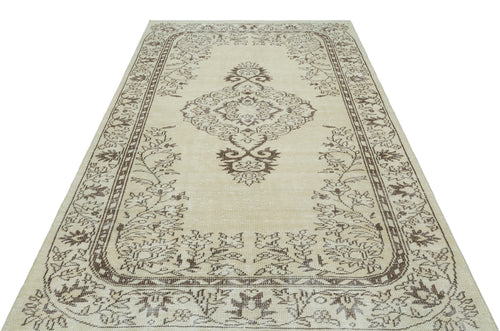 Load image 1 in gallery view. Beige and brown vintage-style rug with a central floral medallion and ornate border pattern on a white background.