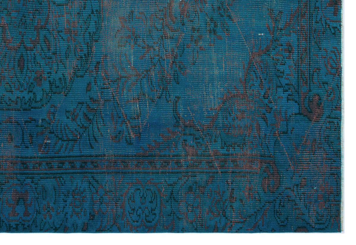 Teal and dark brown distressed rug with a traditional floral medallion pattern and a detailed border.