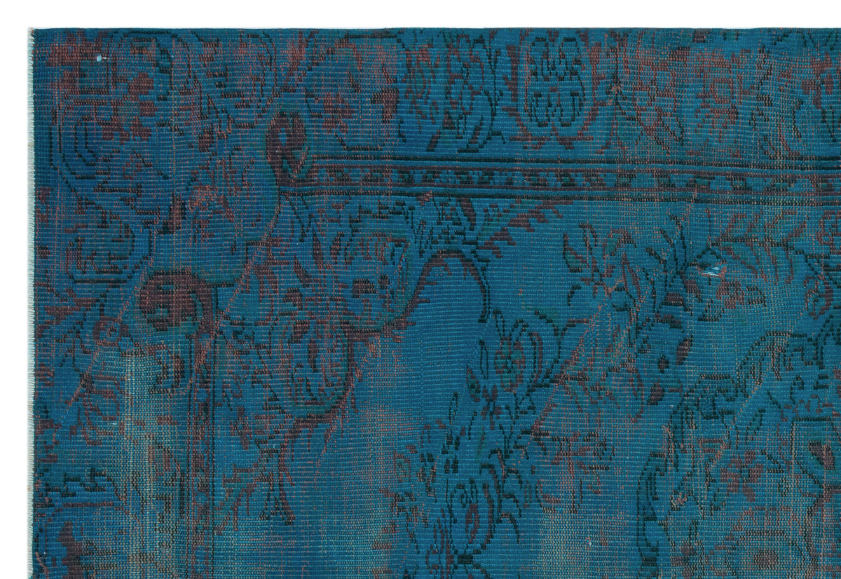 Teal and dark brown rug with a distressed, traditional floral medallion pattern.