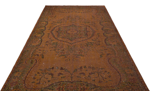 Load image 1 in gallery view. Distressed rust-orange vintage rug with a central medallion and dark green floral border on a white background.