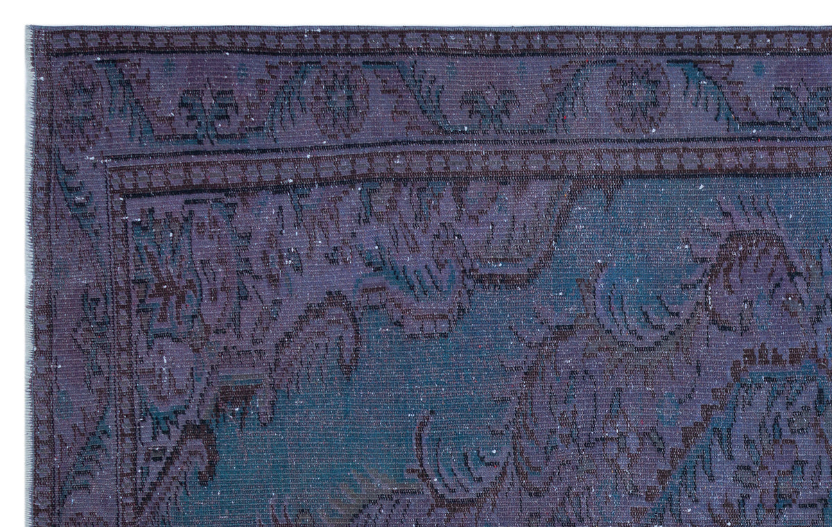 Deep purple and teal vintage-style rug with a distressed floral medallion pattern and a detailed border.
