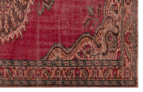Load image 1 in gallery view. Distressed red vintage rug with a dark floral medallion pattern and a geometric border.