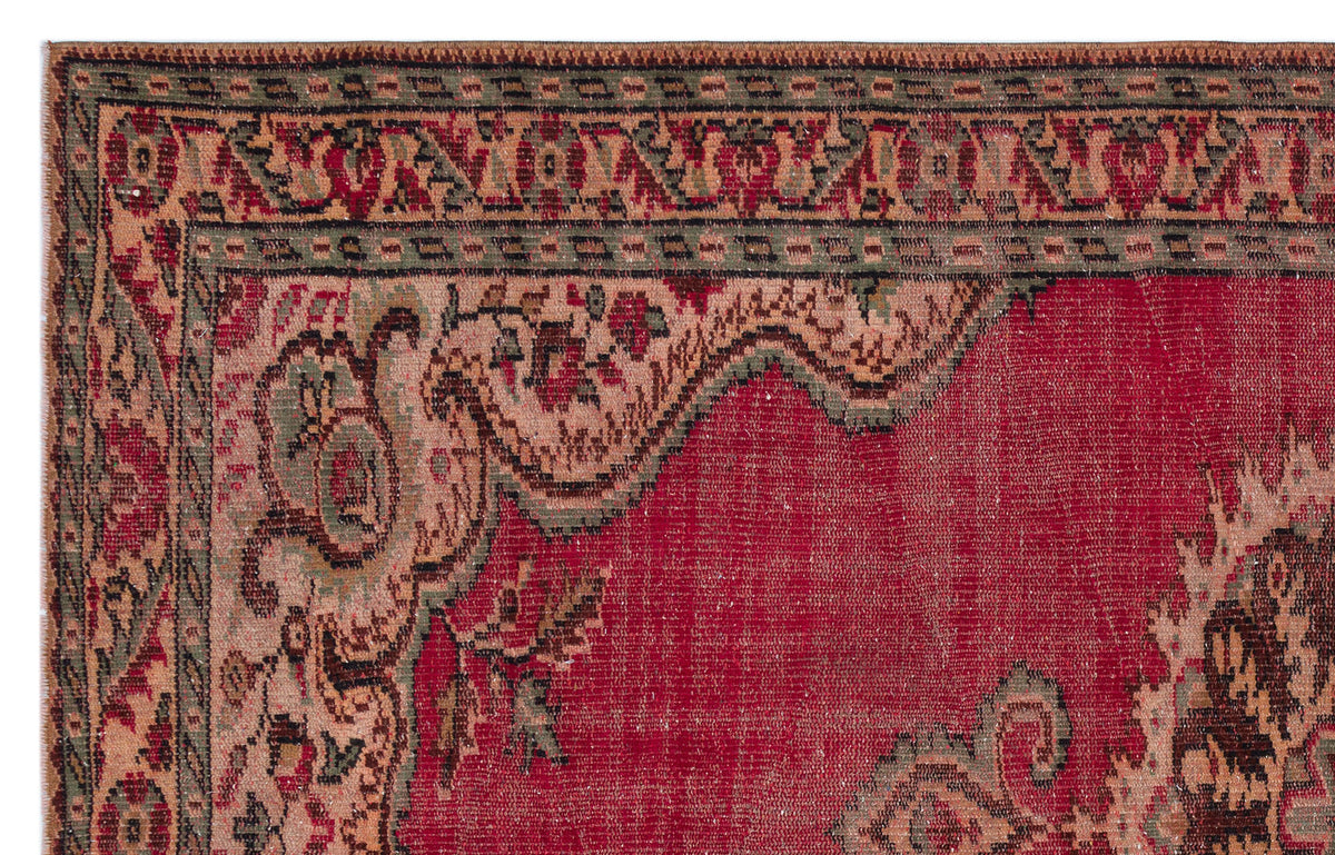Red traditional rug with a dark green and beige floral border and a large central medallion pattern.