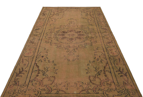Load image 1 in gallery view. Distressed tan and brown vintage-style rug with a central floral medallion and ornate border pattern.