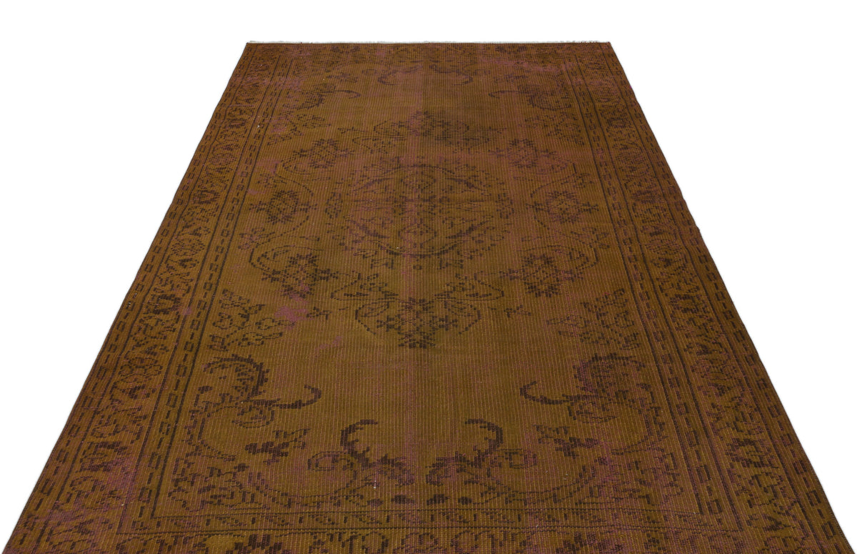 Distressed brown and plum vintage-style rug with a central medallion and ornate border pattern on a white background.