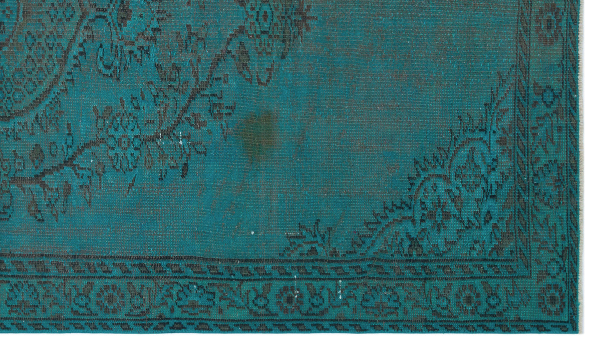 Teal and black distressed rug with a traditional floral medallion pattern and a detailed border.