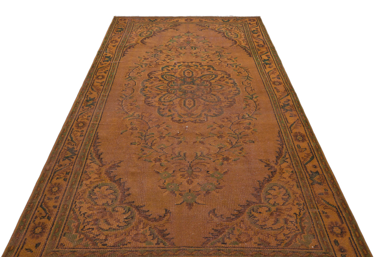 Rust-colored traditional rug with a central floral medallion and intricate border pattern on a white background.
