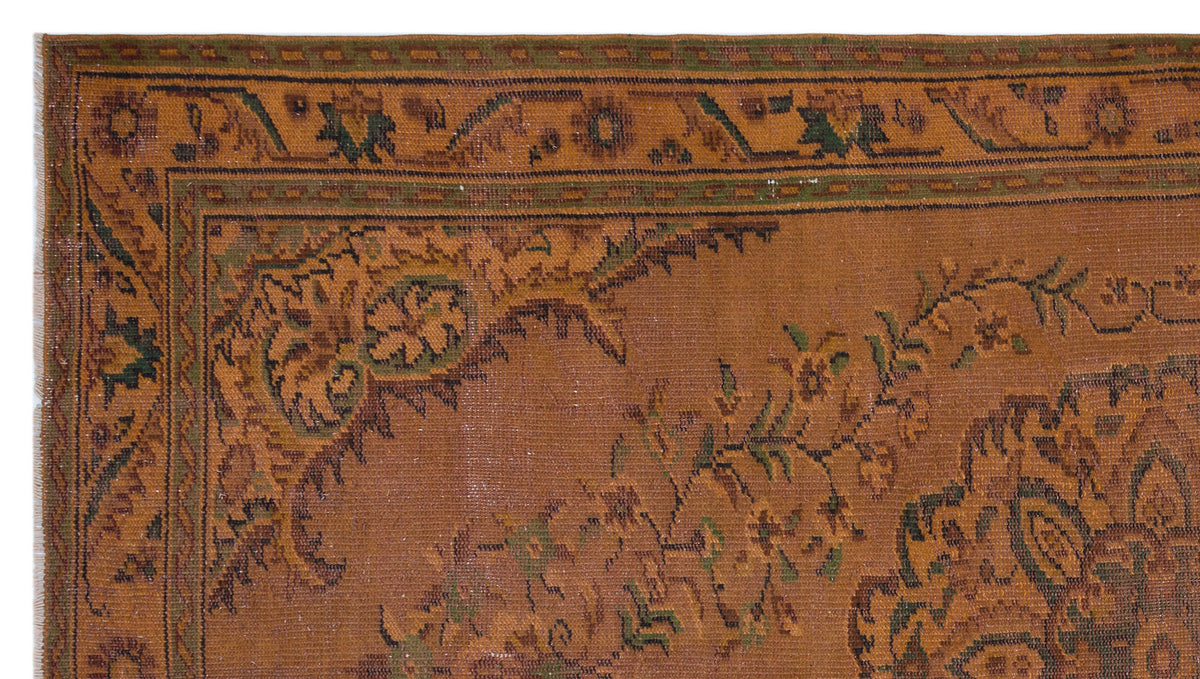 Rust-colored traditional rug with a dark green and brown floral border and central medallion pattern.