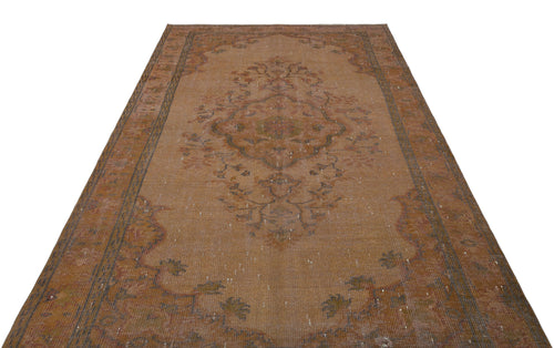 Load image 1 in gallery view. Distressed rust-colored vintage rug with a central floral medallion and ornate border on a white background.