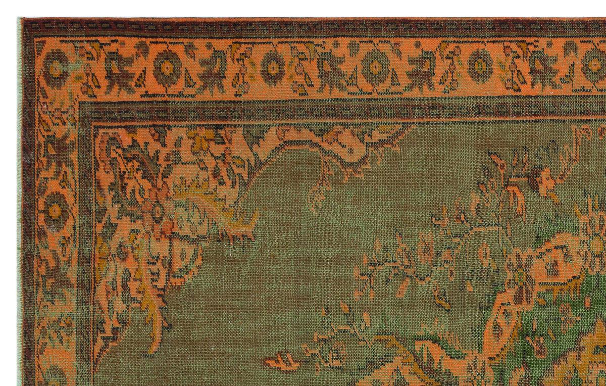 Olive green and burnt orange traditional rug with a distressed floral border and central medallion pattern.