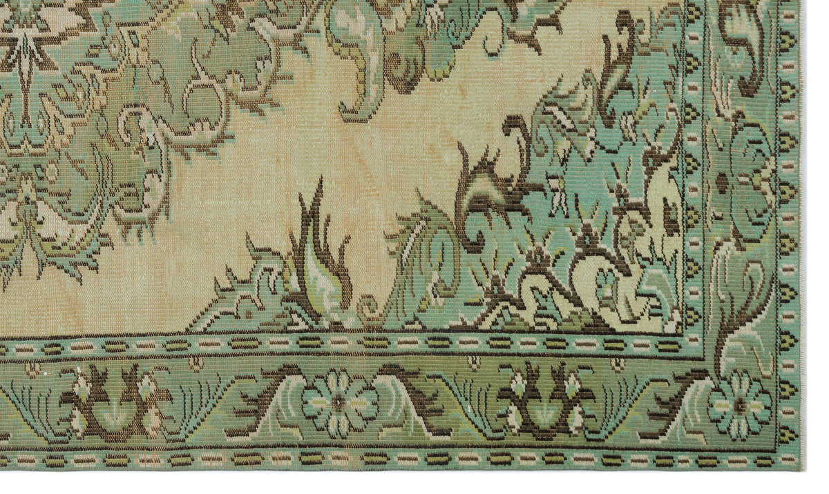 Sage green and beige rug with a traditional floral medallion pattern and a detailed geometric border.