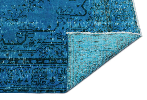 Load image 1 in gallery view. Bright blue distressed rug with a dark geometric medallion pattern and a folded corner showing the lighter blue backing.