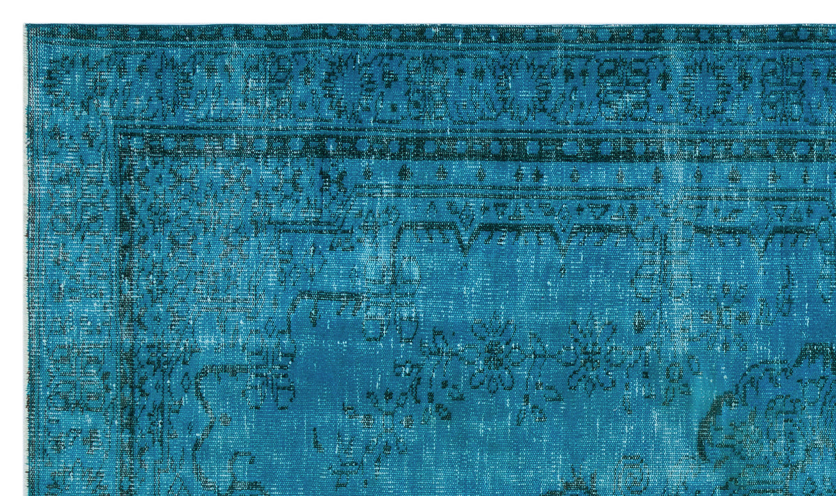 Teal rug with a distressed traditional floral medallion pattern and a dark border.