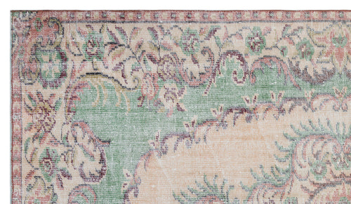 Load image 1 in gallery view. Distressed vintage-style rug with a faded floral medallion pattern in sage green, peach, and deep red on a cream base.