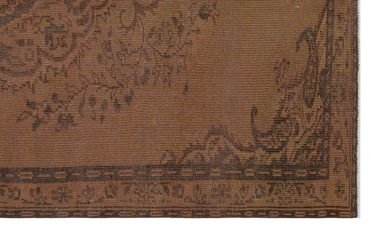 Brown vintage-style rug with a dark brown floral medallion pattern and a geometric border.