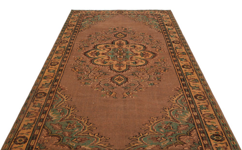 Load image 1 in gallery view. Brown traditional rug with a central floral medallion and ornate geometric border in green and tan accents.