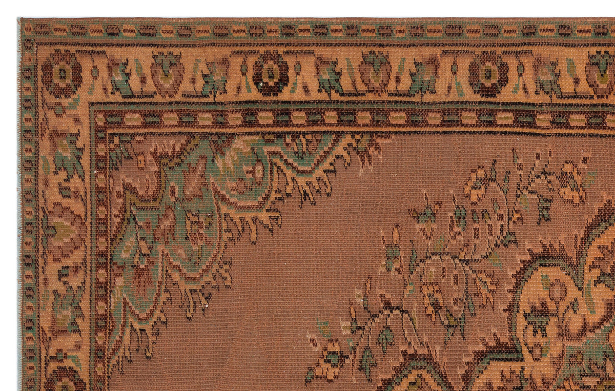 Rust-colored traditional rug with a green and brown floral border and intricate medallion corner detail.