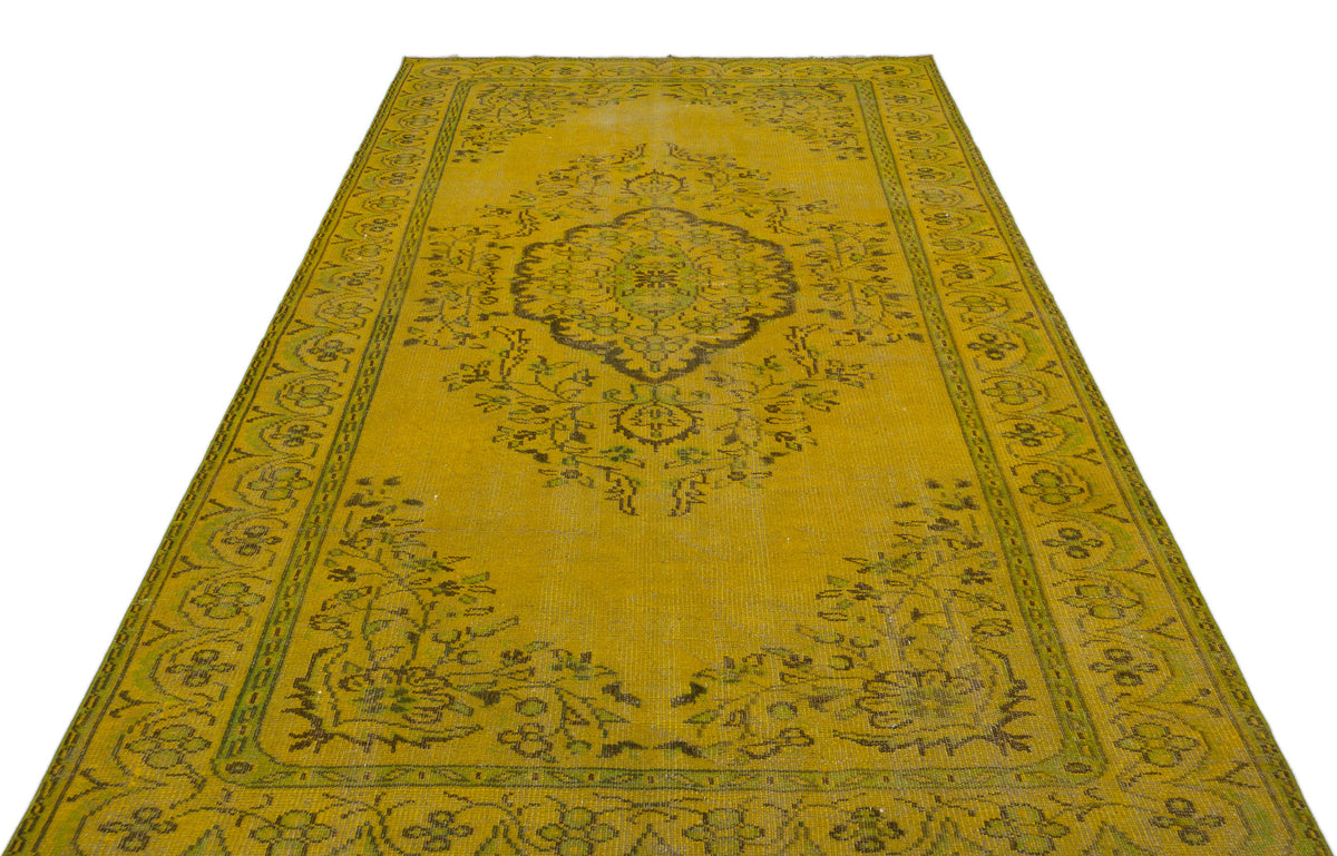 Mustard yellow vintage-style rug with a central dark floral medallion and intricate border pattern.
