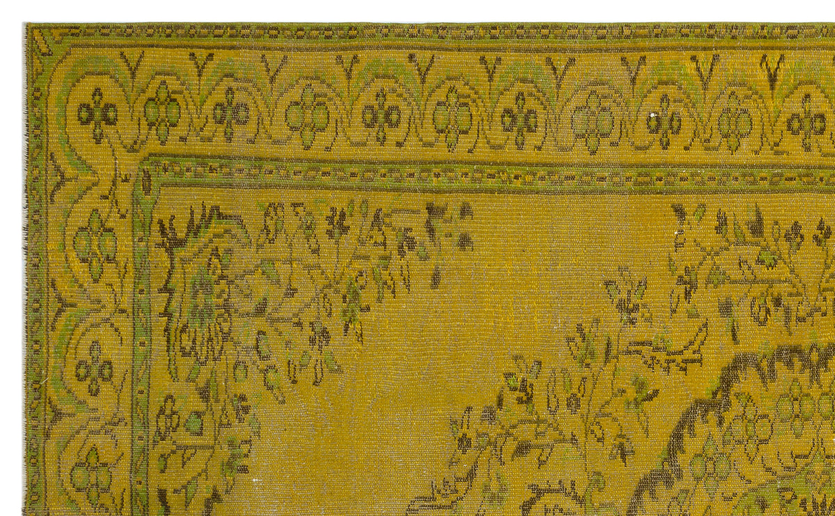 Mustard yellow and olive green vintage-style rug with a decorative floral border and central medallion pattern.