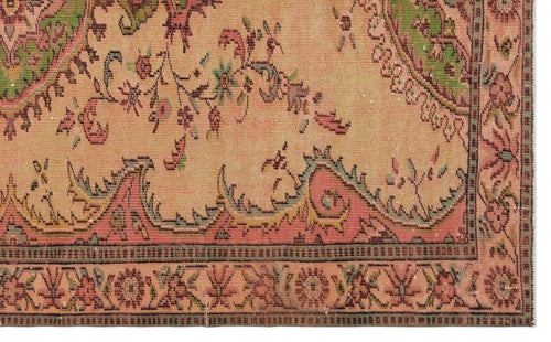 Load image 1 in gallery view. Distressed peach rug with a traditional floral medallion pattern in green, pink, and brown on a white background.
