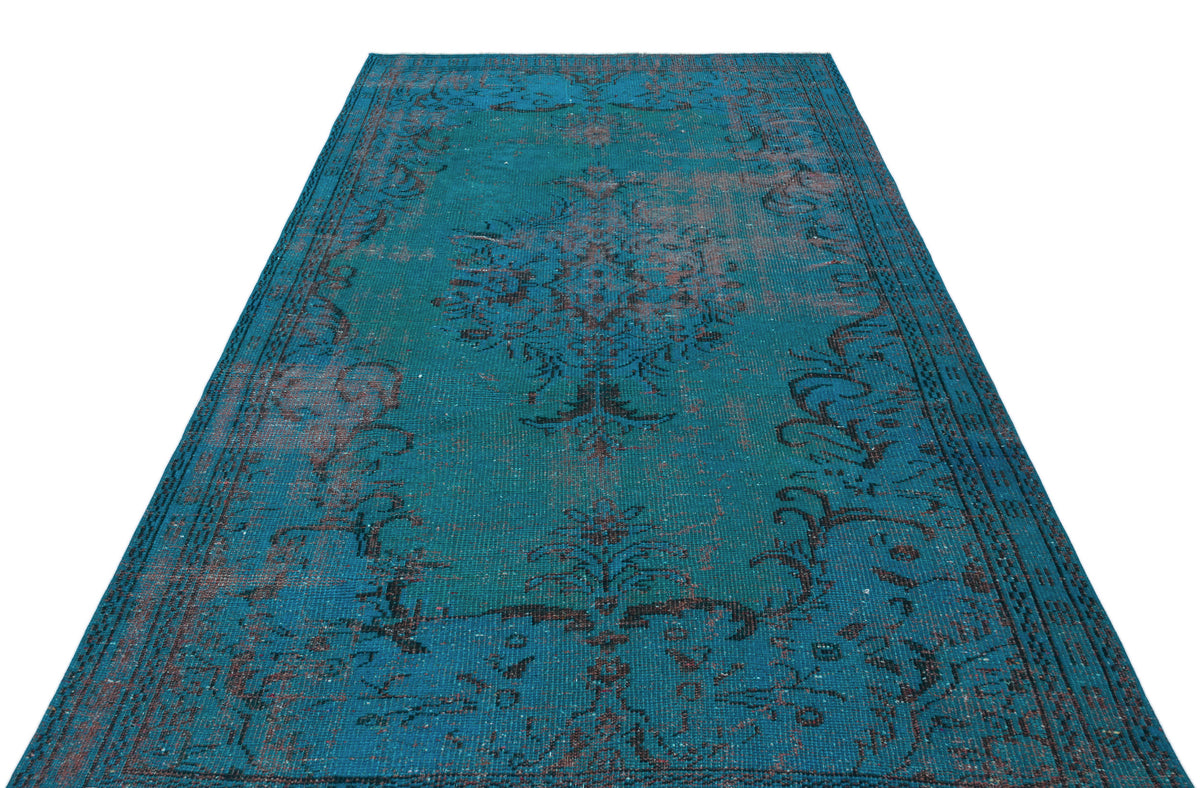 Teal vintage-style rug with a distressed dark brown floral medallion pattern and ornate border.