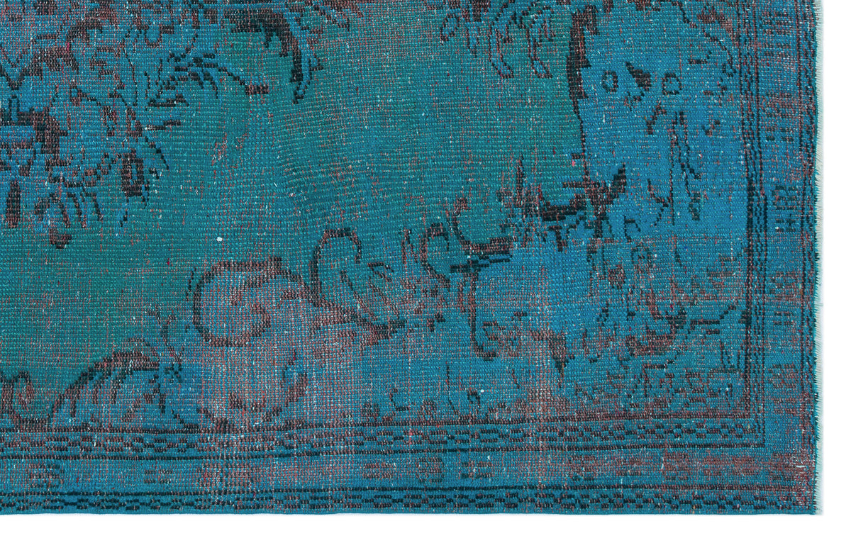 Teal and black distressed rug with a traditional floral medallion pattern and a detailed border.