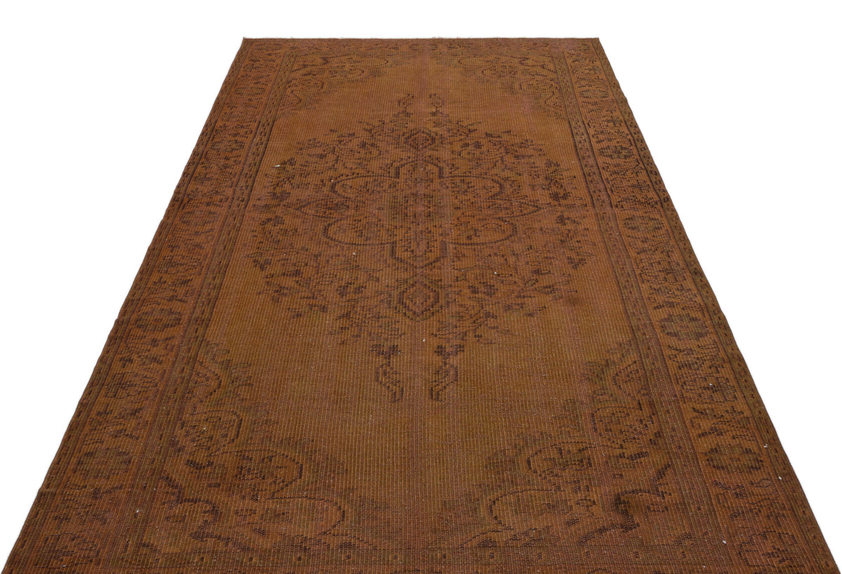 Rust-colored vintage rug with a central medallion and ornate border pattern on a white background.