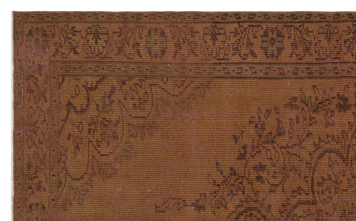 Rust-colored vintage rug with a dark brown floral border and faint, distressed traditional motifs.