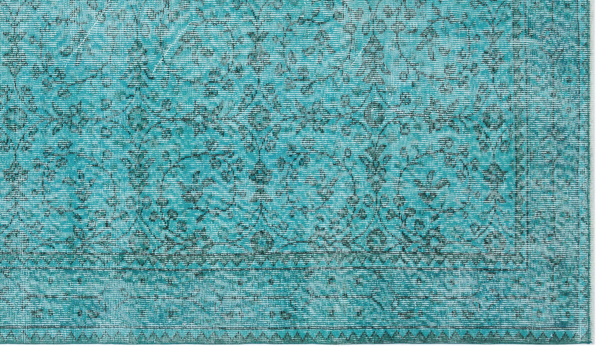 Teal rug with a distressed traditional floral pattern and a geometric border on a white background.