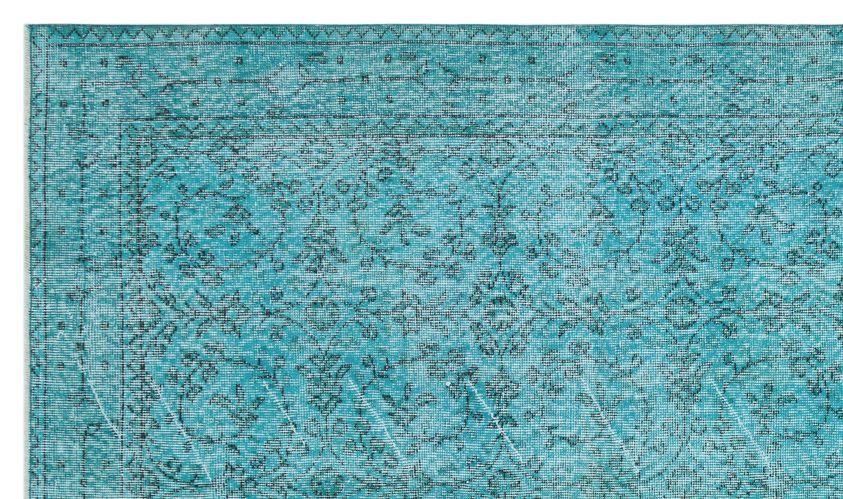 Teal rug with a distressed traditional floral pattern and a geometric border on a white background.