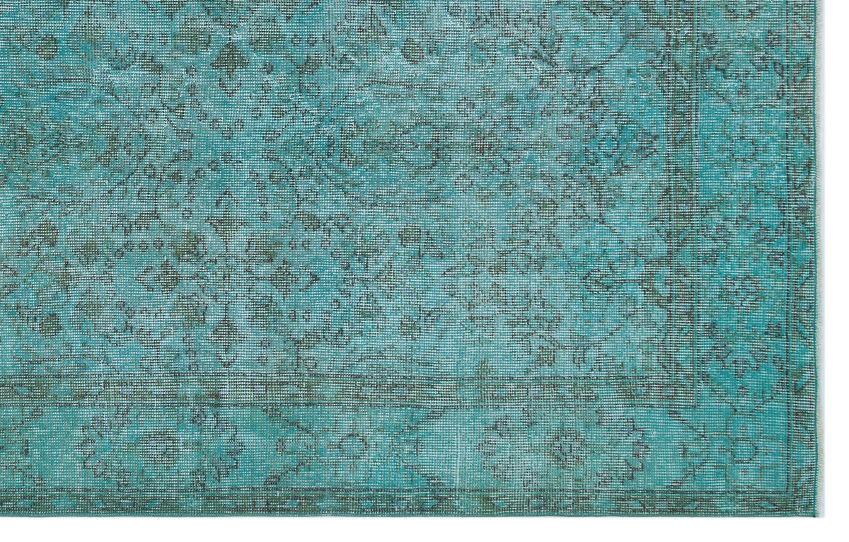 Teal and charcoal distressed rug with a traditional floral medallion pattern and a detailed border.