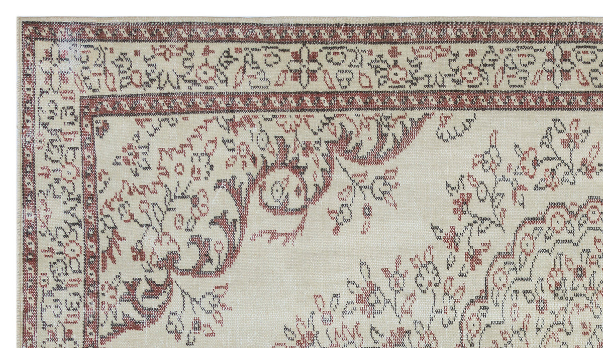 Cream rug with a distressed red and charcoal floral medallion pattern and a decorative geometric border.